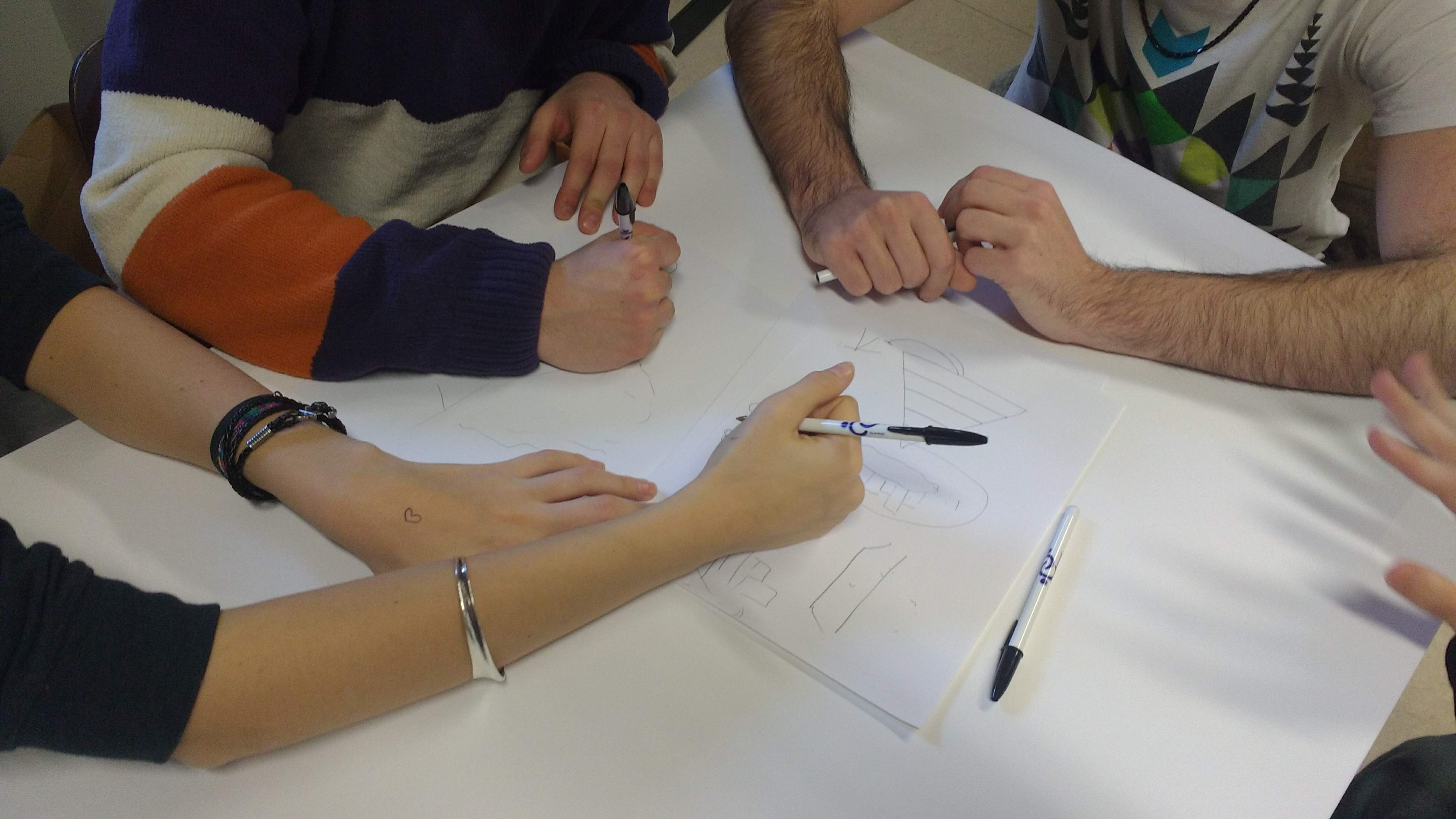 A group of research participants draw together on a piece of paper